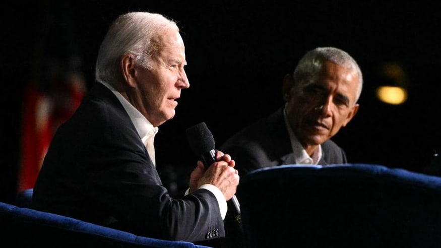 President Joe Biden (L) speaks next to former US President Barack Obama onstage during a campaign fundraiser.