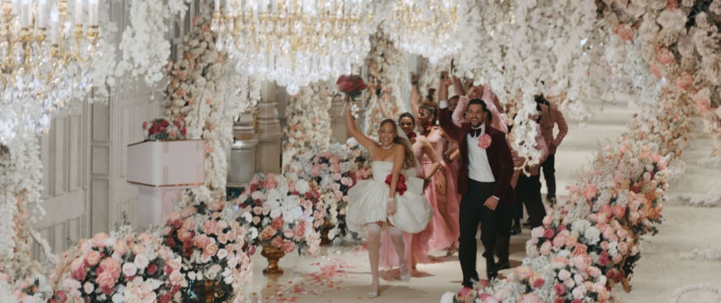 Jennifer Lopez walks down the aisle with a man in a still from ‘This Is Me…Now’