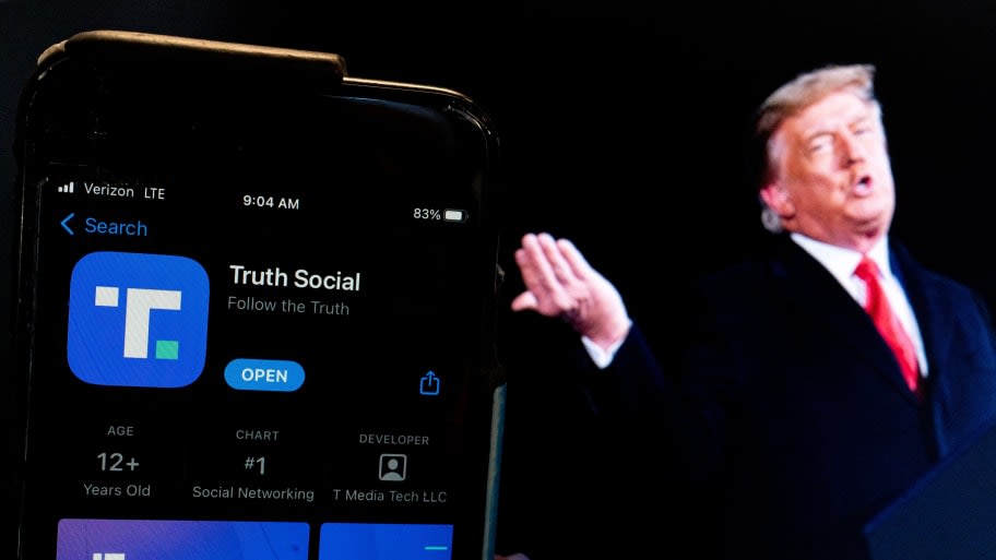 image of trump with phone showing 'Truth Social' App logo