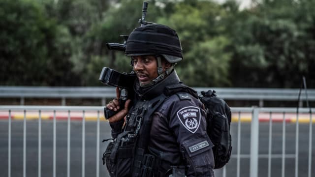 An Israeli police officer stands guard as a search for suspects is underway. Fighting between Israeli soldiers and Islamist Hamas militants continues in the border area with Gaza.