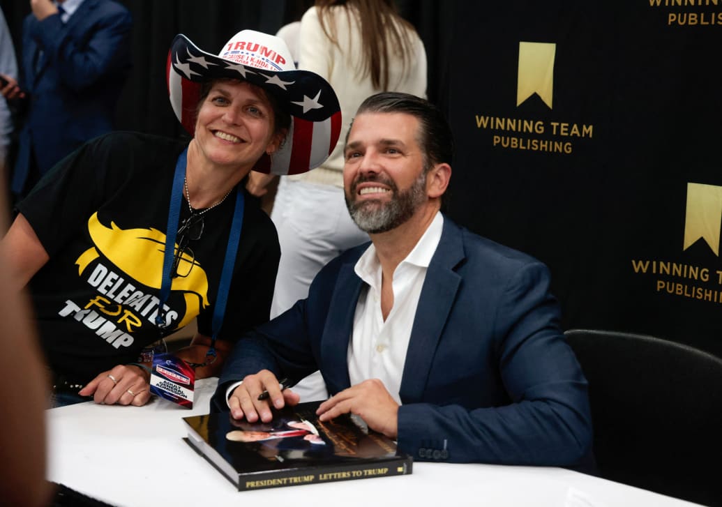 Donald Trump Jr. poses with an attendee during a book signing
