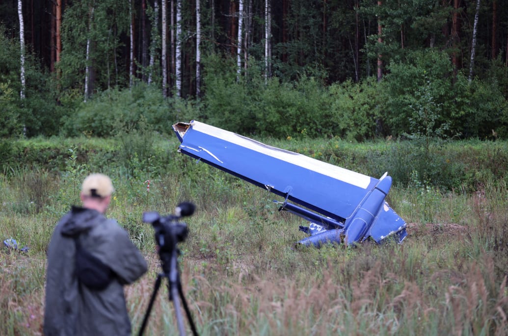 A cameraman films a wreckage of the private jet linked to Wagner mercenary chief Yevgeny Prigozhin near the crash site in the Tver region, Russia, August 24, 2023.