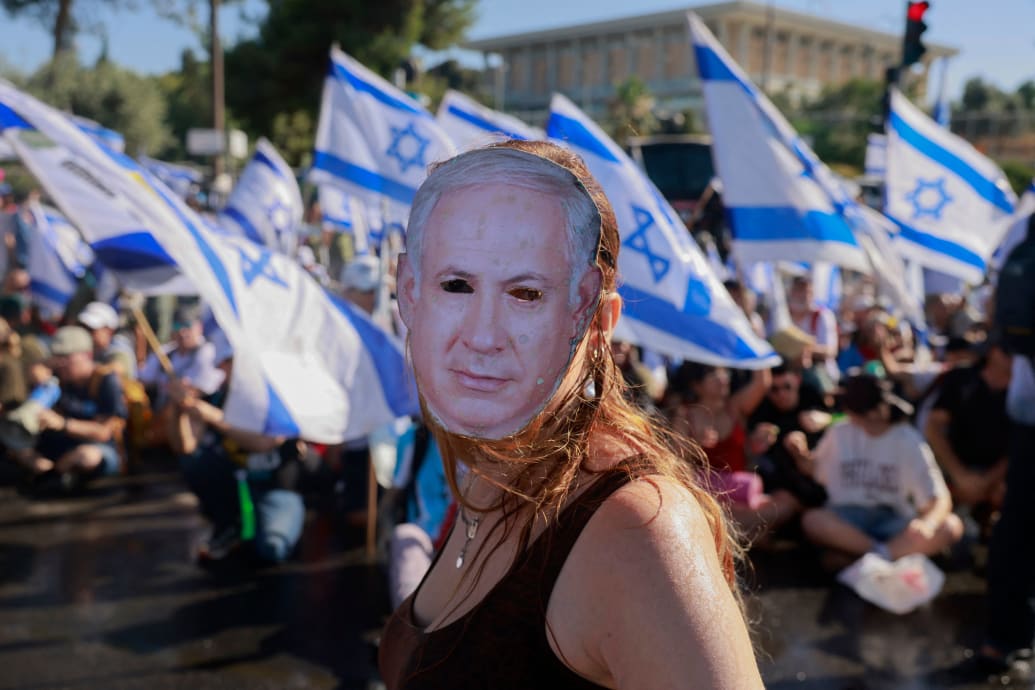 Photo of a demonstrator wearing a mask depicting Israeli Prime Minister Benjamin Netanyahu