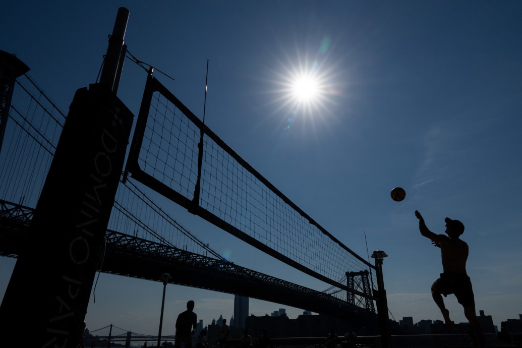 People play beach volleyball in Domino Park in Brooklyn, New York, as a heat wave hits the northeast US on June 18, 2024.