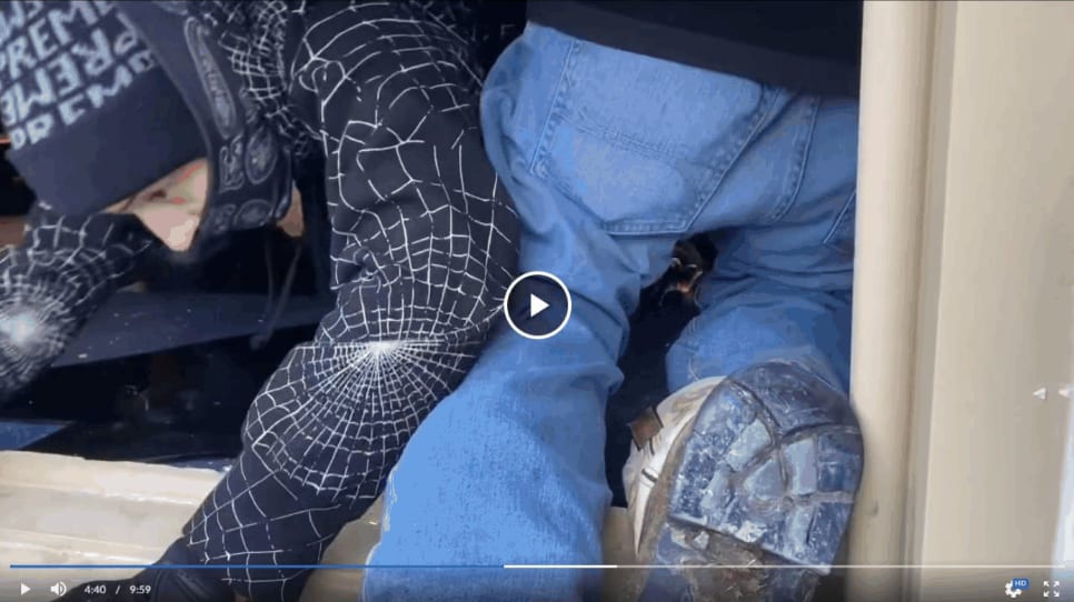 A screenshot of video shows Brandon Kelly Dillard crawling through a broken window