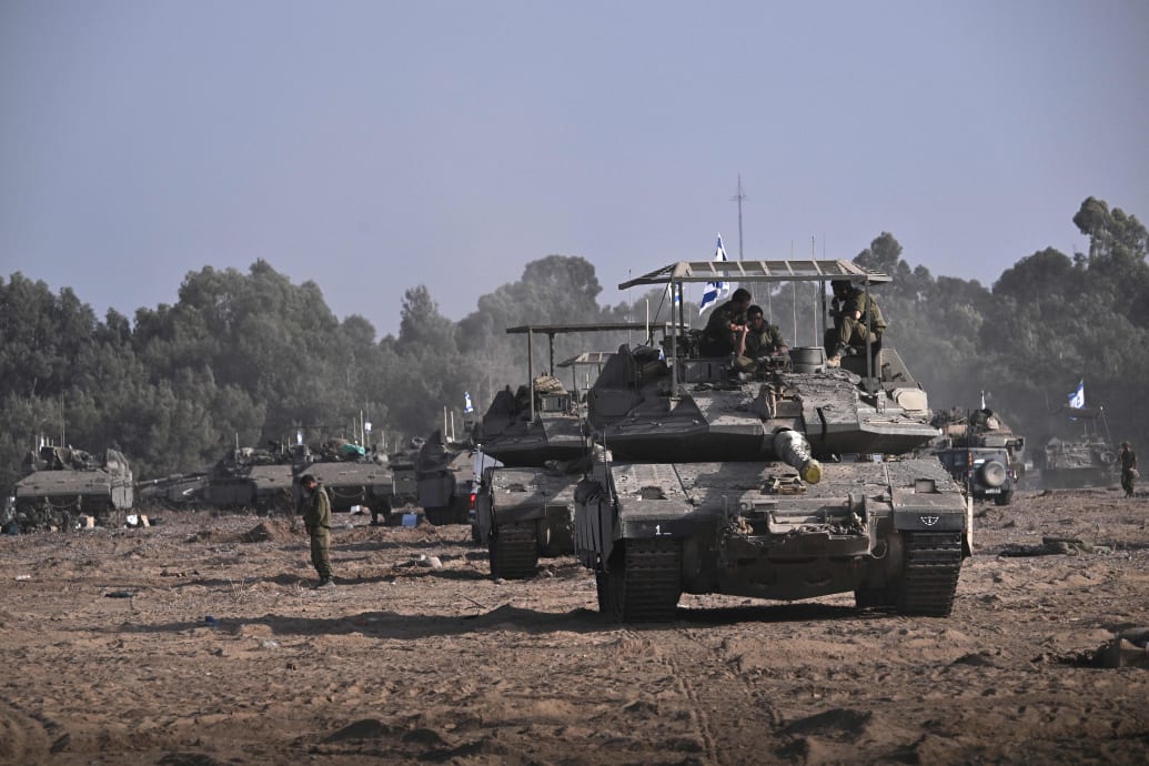Israeli military armoured vehicles and tanks deploy along Israel's border with Gaza on October 24, 2023, amid the ongoing battles between Israel and the Palestinian group Hamas. The tanks are equipped with "cope cages" to deter drone attacks.