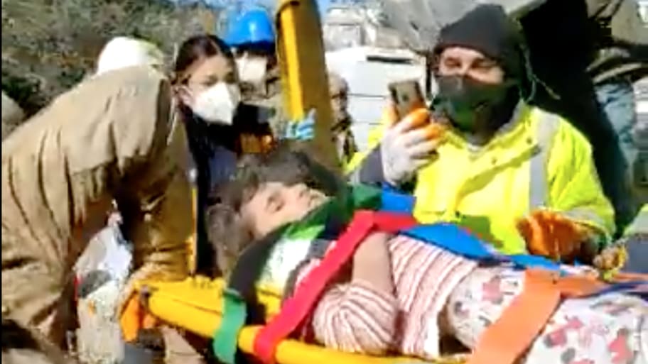 Rescue workers carry a 4-year-old girl away from rubble