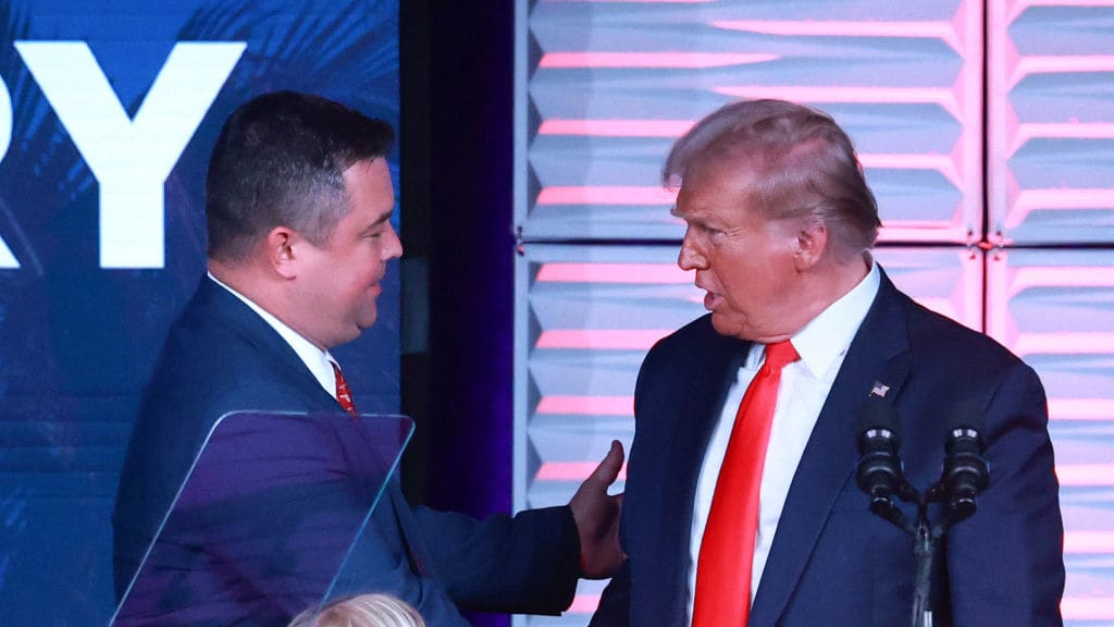 Republican Party of Florida chairman Christian Ziegler, left, greets former president Donald Trump, right.