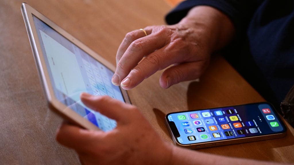 A woman types an e-mail on an iPad