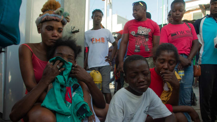 Haitians react after dozens of people were killed in the street by gang members, in Pétionville, Port-au-Prince.