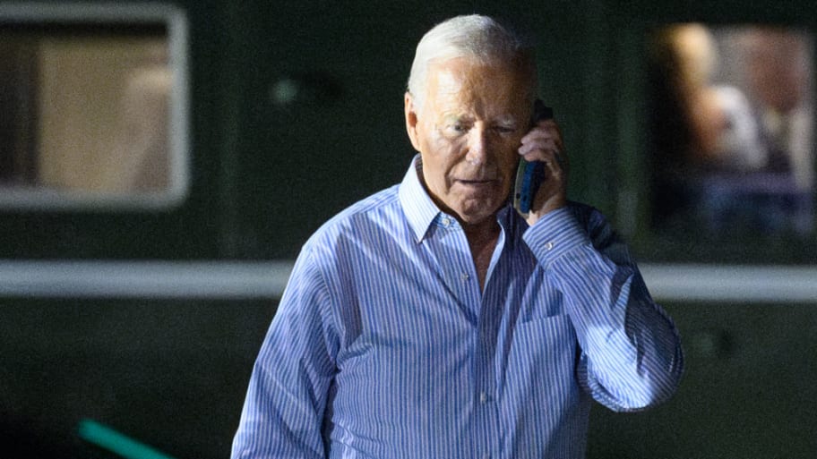 U.S. President Joe Biden speaks on the phone while walking from Marine One to board Air Force One.