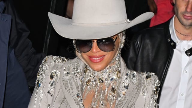 Beyoncé smiles while wearing a cowboy hat.