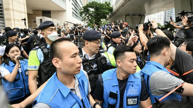 Police try to control media personnel outside the West Kowloon Magistrates’ Court in Hong Kong on May 30, 2024. 