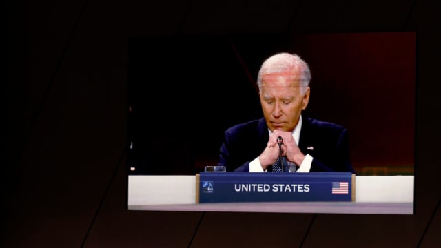 President Joe Biden is seen on a screen as he delivers remarks at a meeting of the heads of state of the North Atlantic Council at the 2024 NATO Summit.