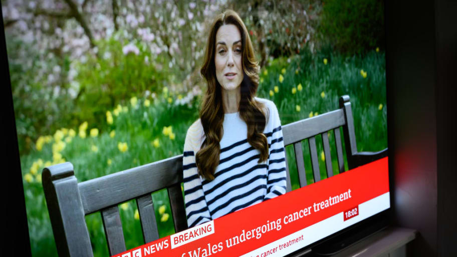 A screen displays a news report as Catherine, The Princess of Wales, announces that she is receiving a preventative course of chemotherapy for cancer.