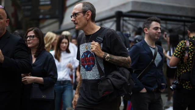 Terry Richardson walks into a Fashion Week in 2017 wearing glasses.