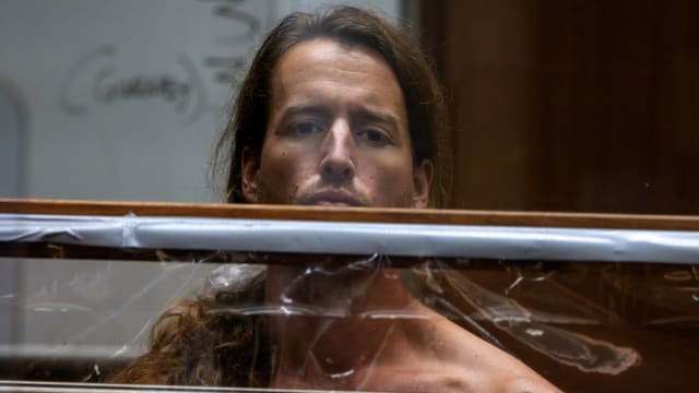 Samuel Haskell IV stands with his chest exposed during a December court hearing for the murder of his wife and in-laws in Los Angeles.