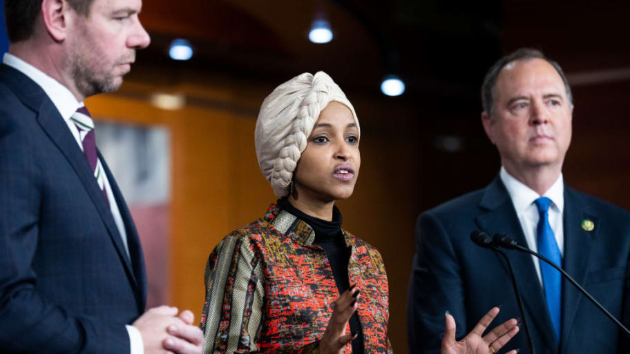 Rep.-elect Ilhan Omar speaks to the press with Rep. -elect Adam Schiff at her right and Rep. -elect Eric Swalwell at her left while they conduct a news conference.