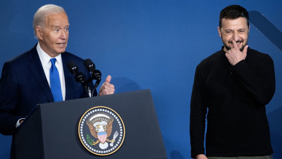 Ukraine's President Volodymyr Zelensky (R) reacts after being introduced as Russia's President Vladimir Putin by US President Joe Biden during a Ukraine Compact event.