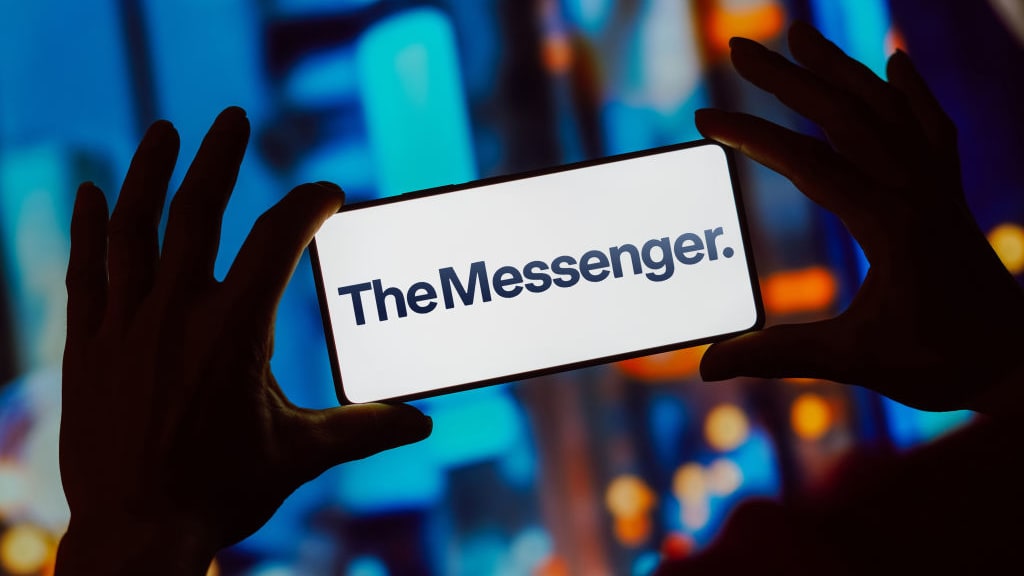 The Messenger is displayed on a phone screen with city lights in the background.