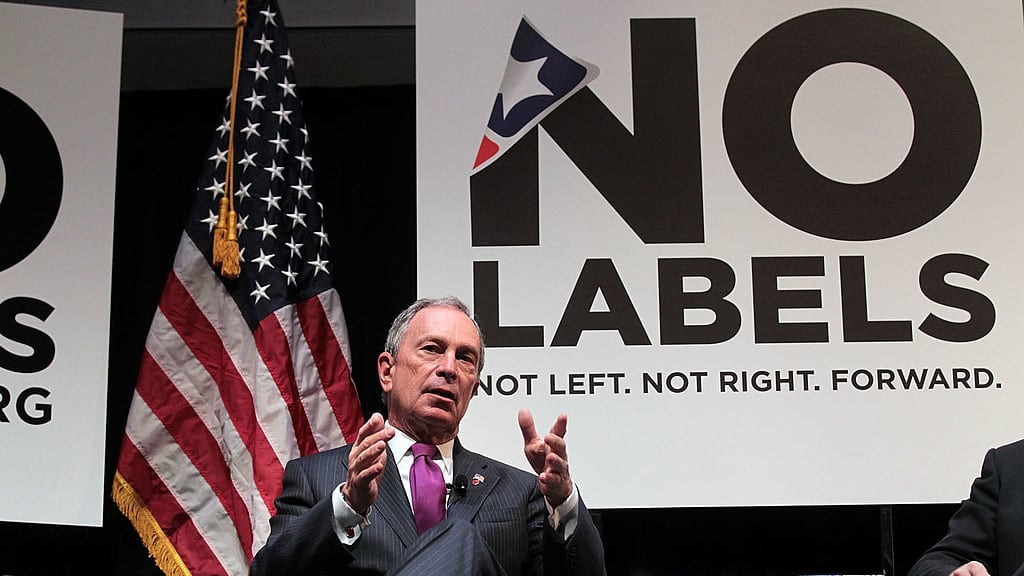 Michael Bloomberg speaks in front of No Labels signage at an event.