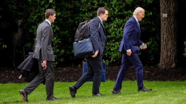 President Joe Biden, accompanied by his personal aide Jacob Spreyer (C) and Assistant to the President & Director of Oval Office Operations Richard Ruffner (L), arrive at the White House. 