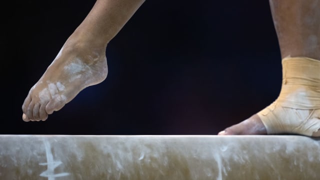 A generic photo of gymnasts’ feet on the balance beam