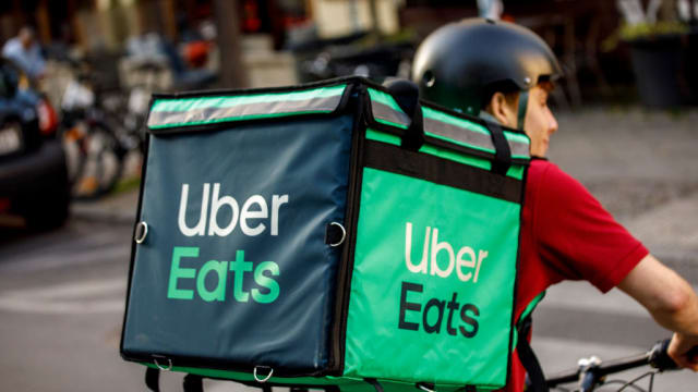 A driver for food delivery service Uber Eats, rides a bicycle with a transport box on his back