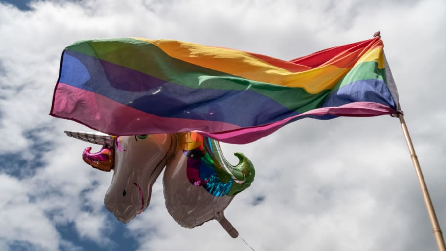 A unicorn balloon and a LGBTQ+ flag.