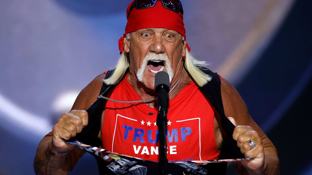Donald Trump blaast een kus in de lucht terwijl Hulk Hogan zijn shirt uittrekt op het podium in een surrealistische scène op de Republikeinse Nationale Conventie