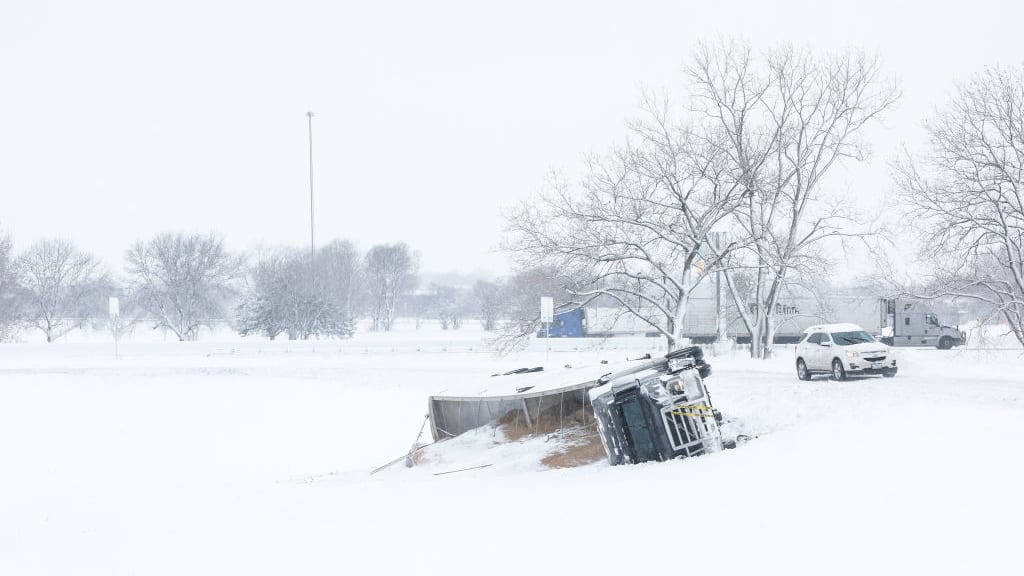 A semi-truck is seen toppled over on the side of a road amidst a snowstorm on January 09, 2024 in Des Moines, Iowa.
