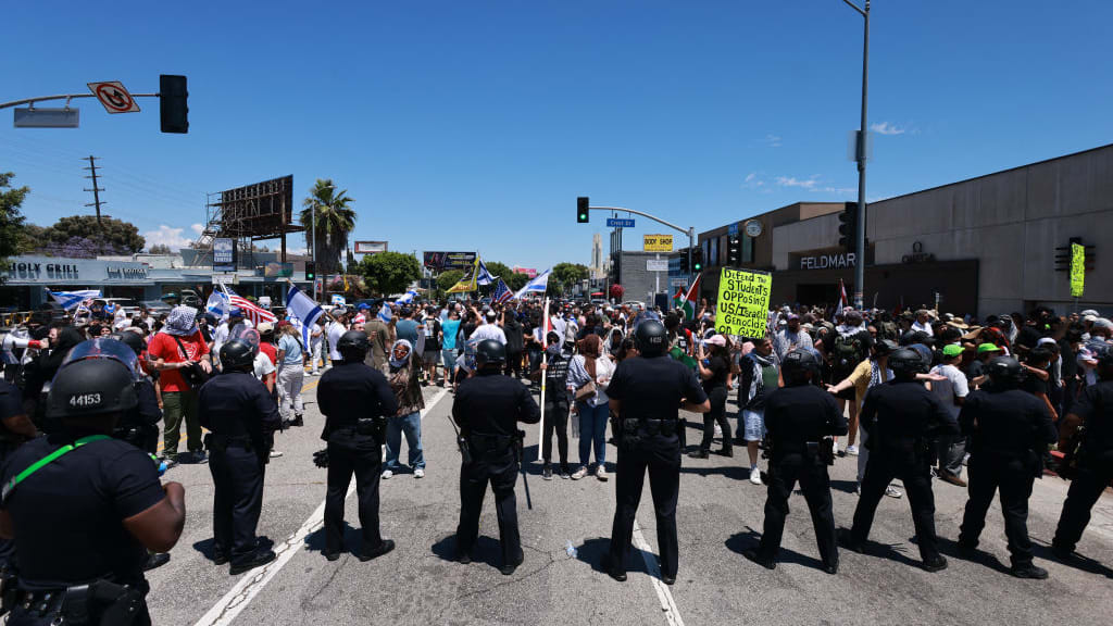 Los Angeles Police Department (LAPD) officers line up in front of anti-Israel protesters gathered outside the Adas Torah Orthodox Jewish synagogue in Los Angeles