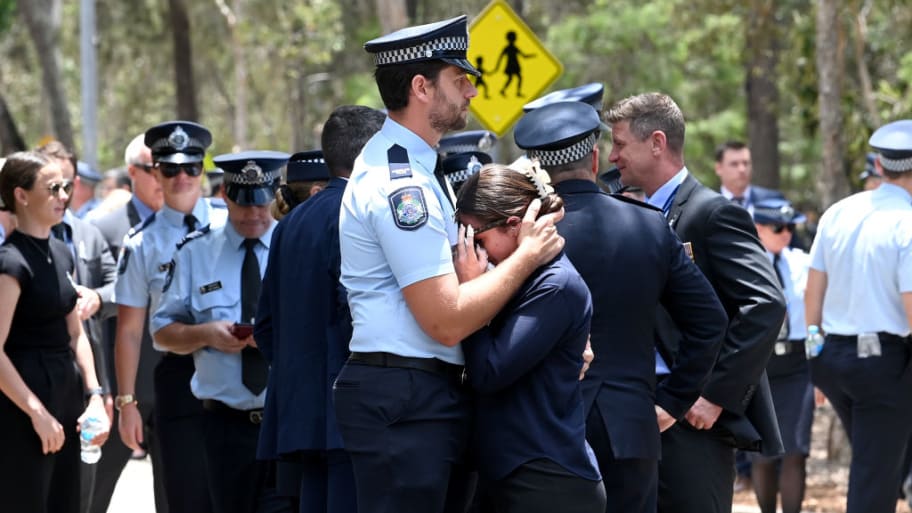A young police officer is embraced Dec. 21, 2022, in Brisbane, Australia.