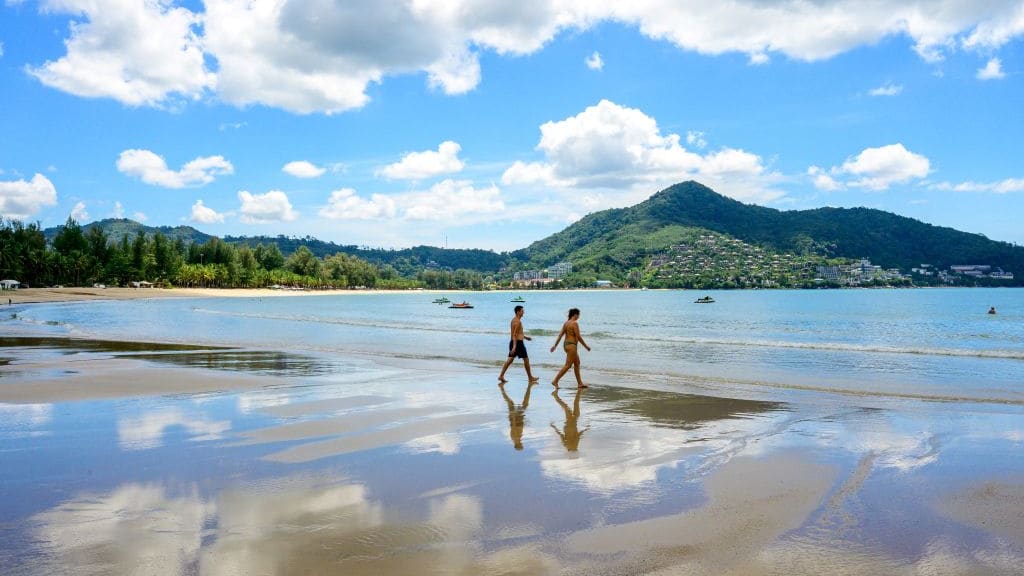 Tourists walk on a beach on the Thai island of Phuket on November 1, 2021.