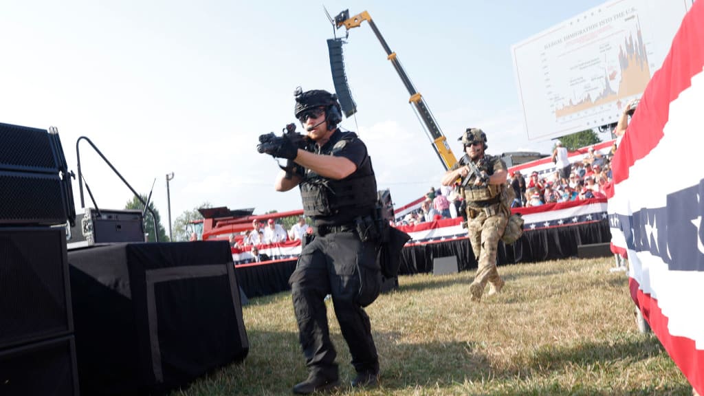 Law enforcement officers move following a shooting during a rally held by Donald Trump in Butler, Pennsylvania.