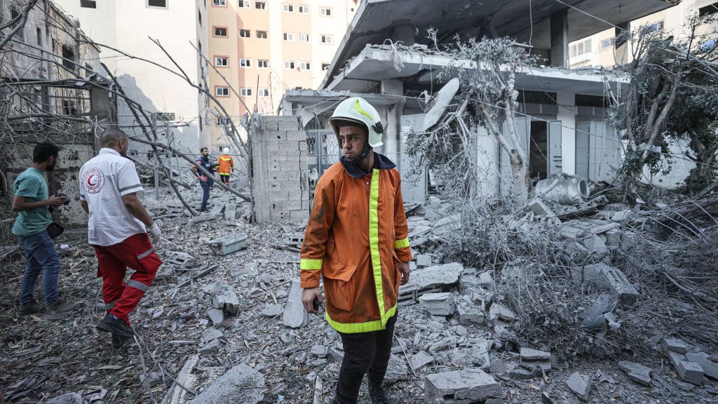 A man searches through the rubble after Israeli airstrikes hit Gaza, a day after Hamas militants invaded Israel.