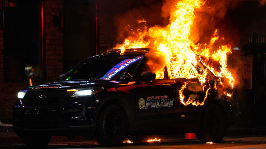 An Atlanta police vehicle in flames during a "Cop City" protest in Georgia