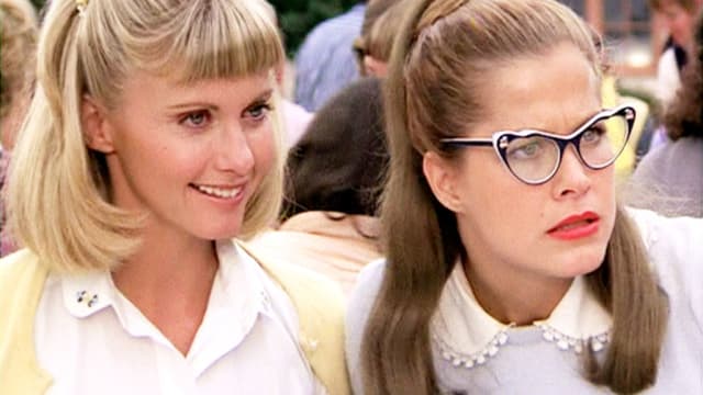 Olivia Newton-John as Sandy Olsen, left, and Susan Buckner (wearing cat's eyes glasses) as Patty Simcox.