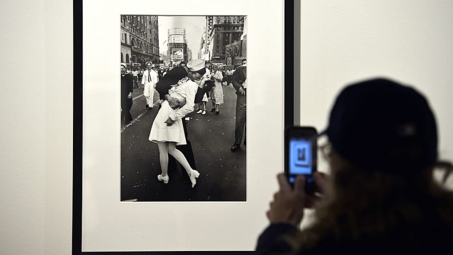 A visitor takes a snapshot  of “VJ Day in Times Square” by Alfred Eisenstaedt during the “Life — The great photographers” exhibit in Rome.