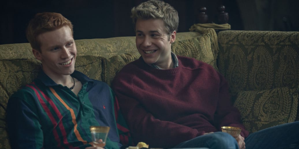 Ed McVey and Luther Ford sit on a couch in a still from ‘The Crown’