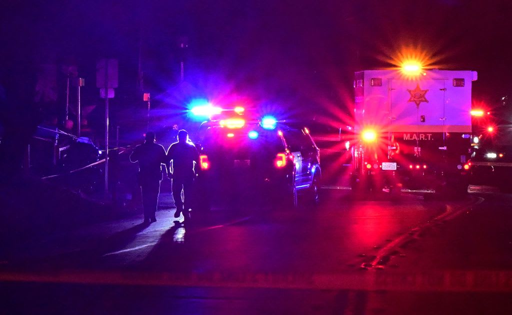 Red-and-blue police lights shine outside the scene of a California bar shooting.