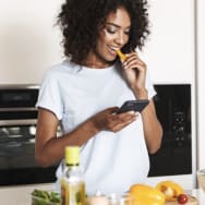 Woman eating food while checking her phone. 
