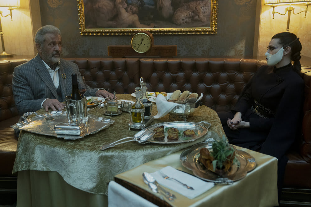 Photo still of Mel Gibson as Cormac and Katie McGrath as Adjudicator in 'The Continental'