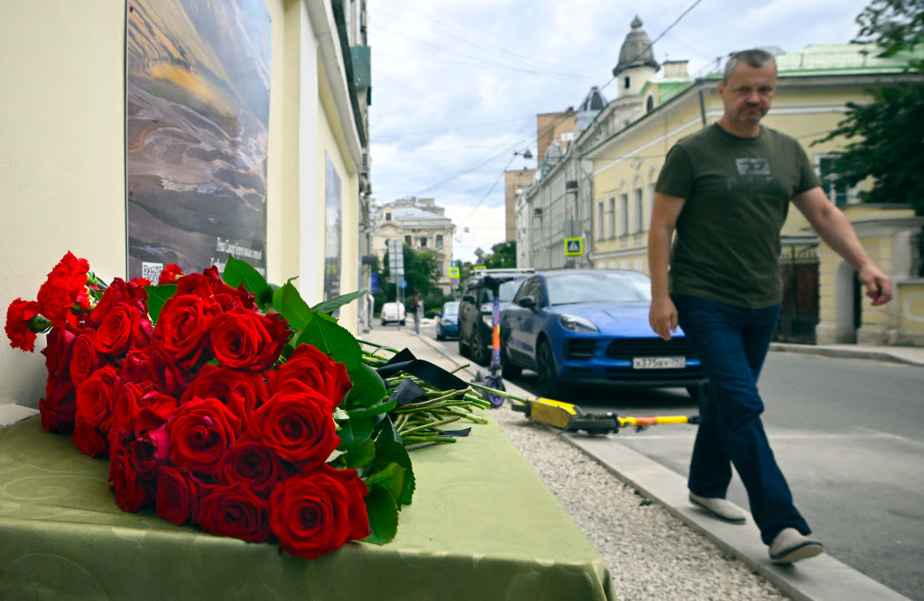 A man walks past flowers laying in front of the representative office of Dagestan in Moscow. 
