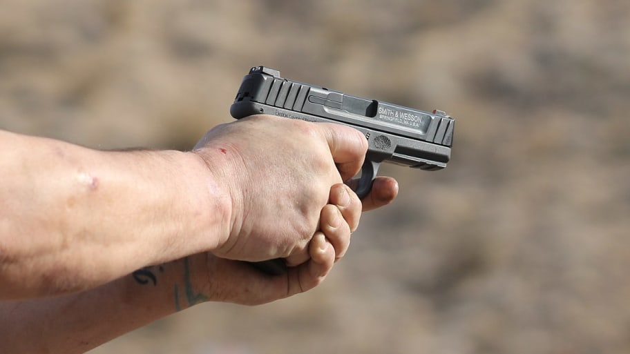 A man aiming a Smith & Wesson SD9 at an outdoor shooting range in Nevada.