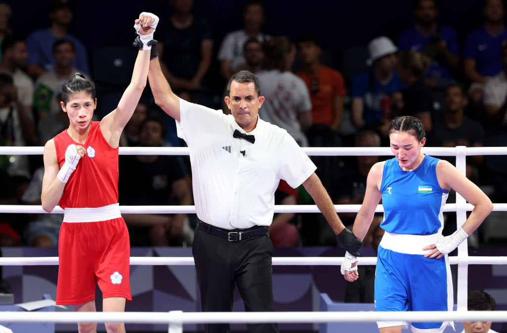 Taipei's Yu Ting Lin, red, raises her arm in victory as Uzebekistan's Sitora Turdibekova looks away at the 2024 Paris Olympics. 