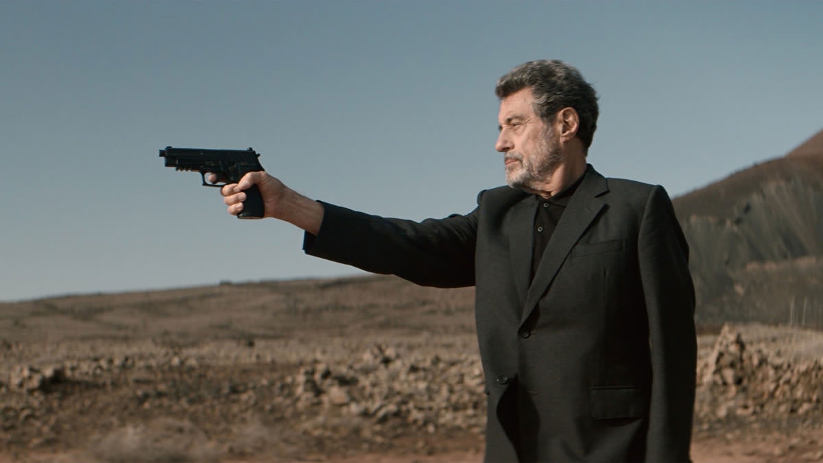 Ian McShane holds a gun up in a still from ‘American Star’