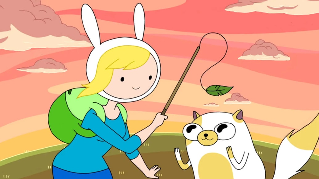 A still from Adventure Time that shows Fionna teasing Cake with a stick with a leaf attached to it