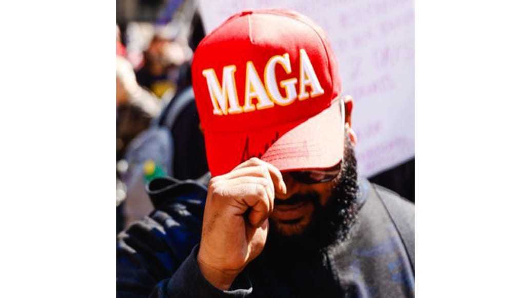 A photo of Vish Burra in a signed MAGA hat.