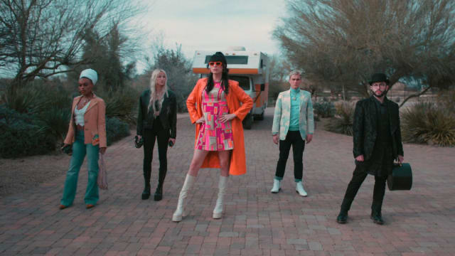 Juju Bae, Alex LeMay, Roz Hernandez, Logan Taylor and Ken Boggle pose on a desert road in front of their RV in a still for ‘Living for the Dead’